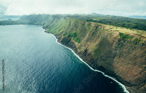 Beautiful Aerial Scenic View Photo of Molokai Sea Cliffs From The Air with Deep Blue Ocean Water Below in Tropical Island Paradise in Hawaii