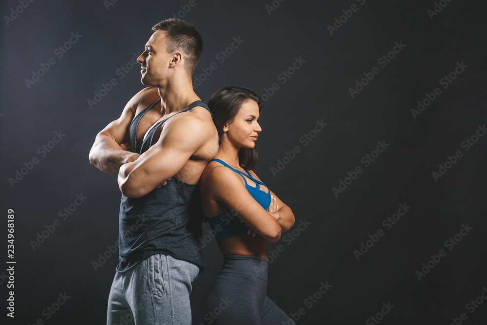 Obraz premium Sporty young sexy couple isolated over black background.