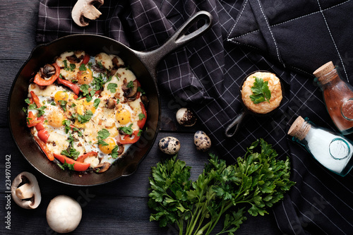 Fried eggs with bacon, mushrooms, bell peppers and greens