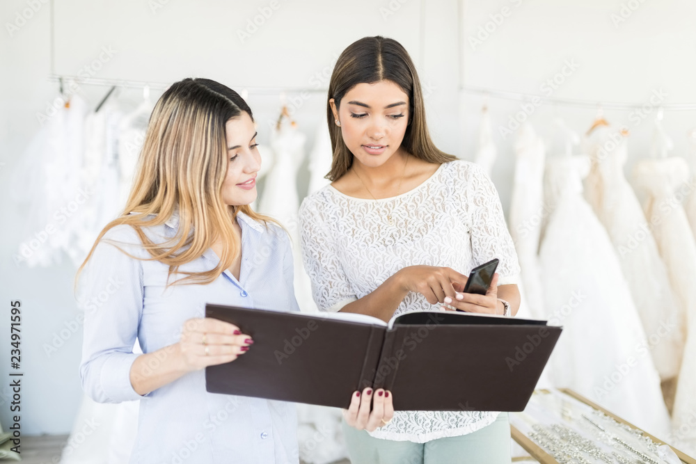 Customer Showing Her Bridal Dress Choice To Store Owner Customer Showing Her Bridal Dress Choice To Store Owner