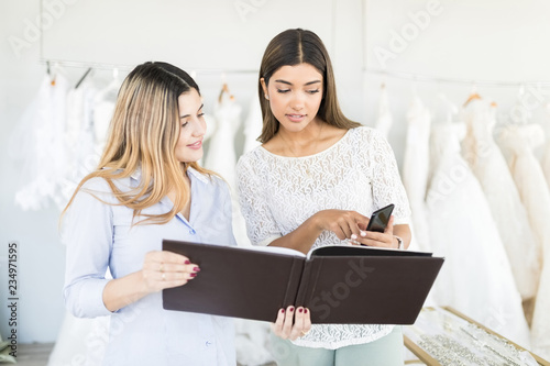 Customer Showing Her Bridal Dress Choice To Store Owner