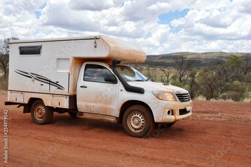 one man sitting in a white camper van in the australian outback