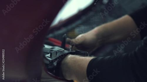 car mechanic installs protective mesh