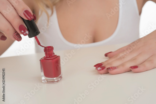 woman painting her nails on her hands with red nail polish