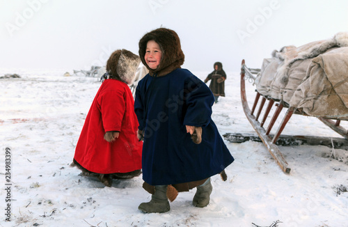 A resident of the tundra, indigenous residents of the Far North, tundra, open area, children ride on sledges, children  in national clothes,boy in the a Nenets-Malitsa clothing