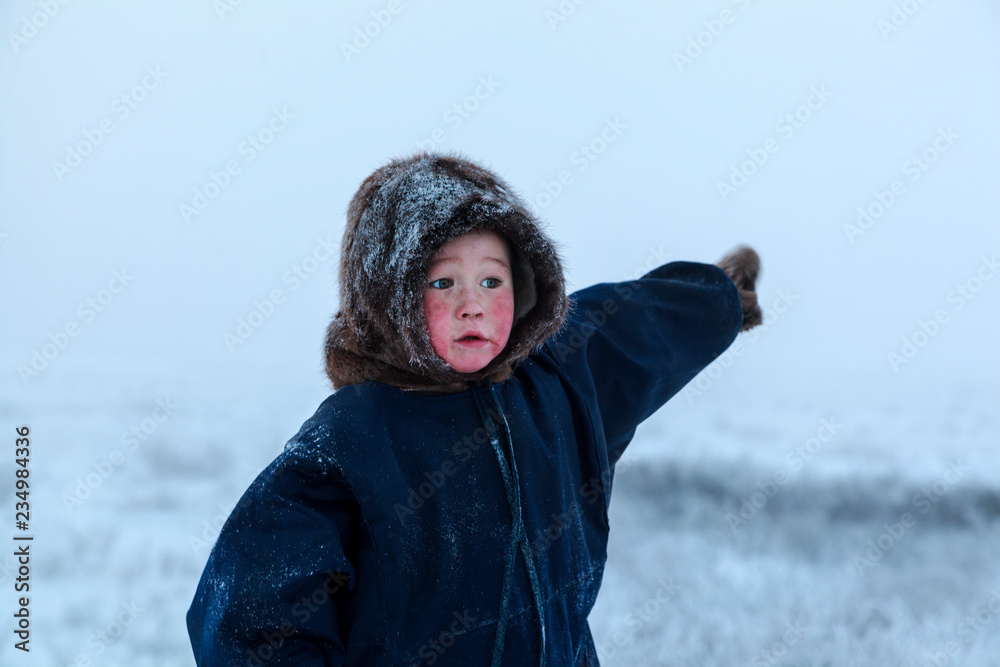 A resident of the tundra, indigenous residents of the Far North, tundra, open area, Boy shows direction with his hand A resident of the tundra, indigenous residents of the Far North, tundra, open area, Boy shows direction with his hand