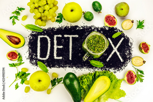 Concept of diet, word detox is made from black cumin seeds. Green smoothies and ingredients. Aavakado, figs, feijoa, cleansing the body, healthy eating. Written word detox photo