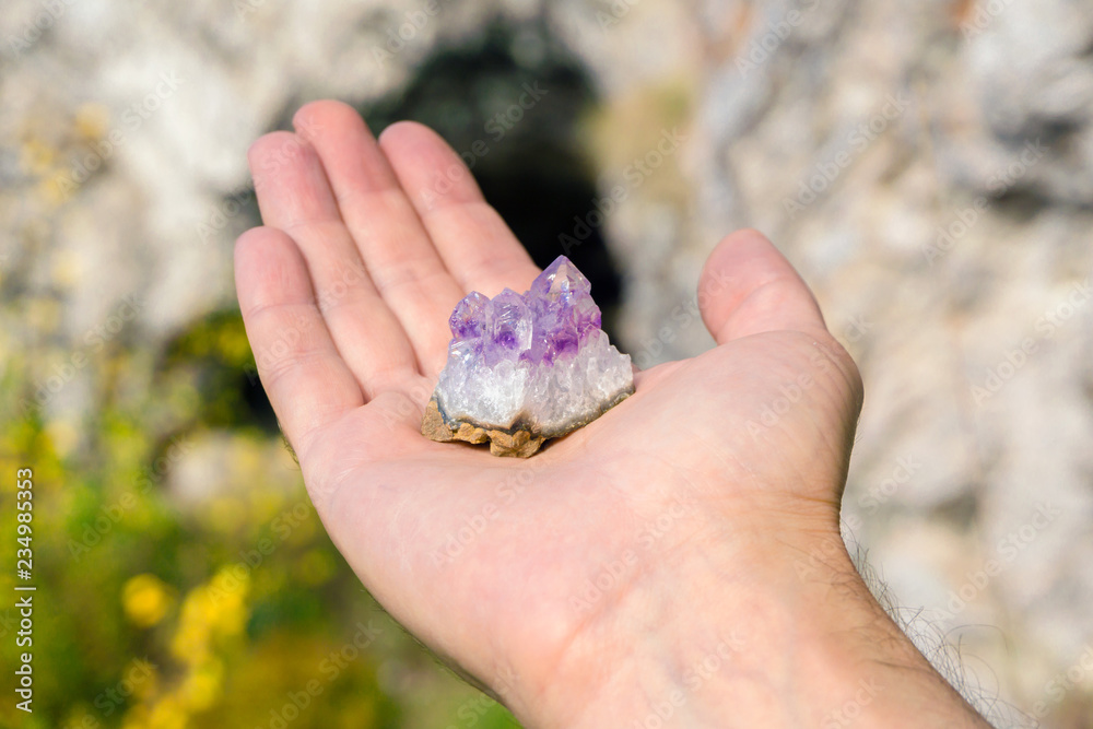 druse of natural untreated violet crystals of amethyst on a piece of rock lies on the palm of your hand druse of natural untreated violet crystals of amethyst on a piece of rock lies on the palm of your hand