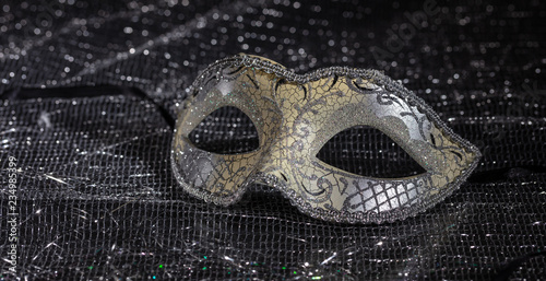 Carnival mask on black shiny background, closeup view