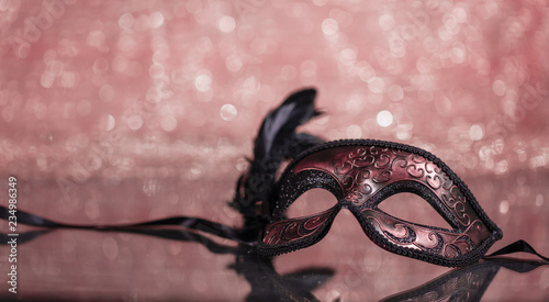 Carnival mask with feathers on bokeh background