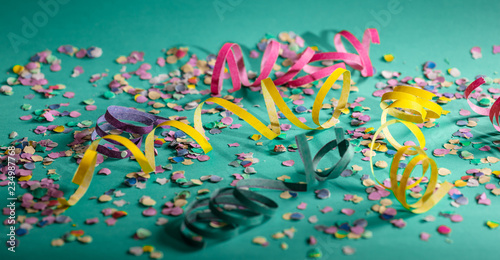Carnival or birthday party, confetti and serpentines on bright green background