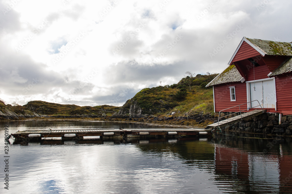 Naklejka premium Rotes Bootsaus mit Anlegeplatz