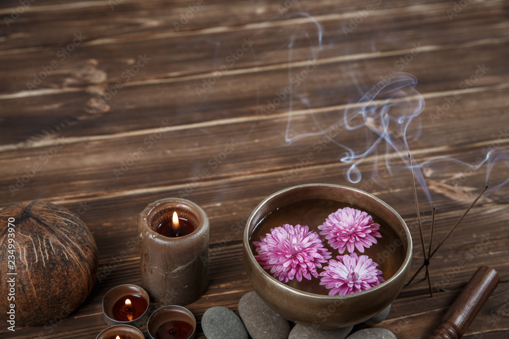 Singing bowl with candles with pebbles on dark wooden background Singing bowl with candles with pebbles on dark wooden background