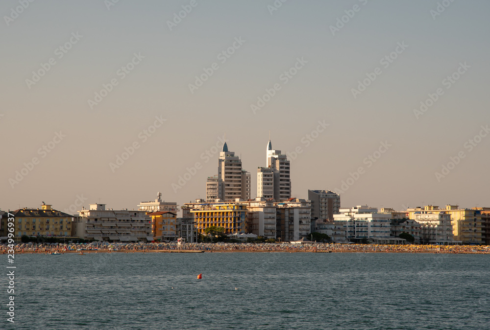 Obraz premium Coast city with skyscrapers and beach on the sea at sunset, Jesolo Lido, Venice, Italy