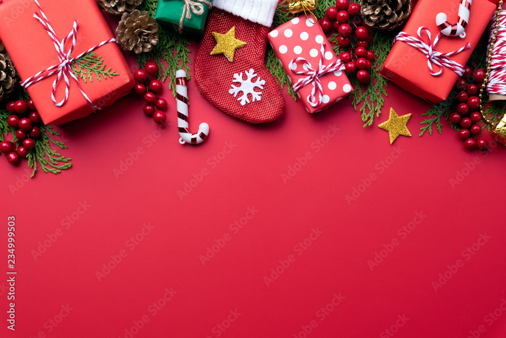 Christmas background concept. Christmas gift box with red sock and decoration on red background.