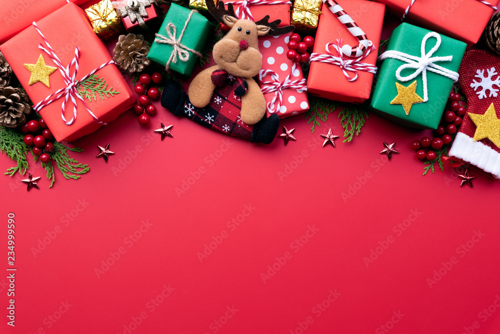 Christmas background concept. Christmas gift box with reindeer and decoration on red background. Christmas background concept. Christmas gift box with reindeer and decoration on red background.