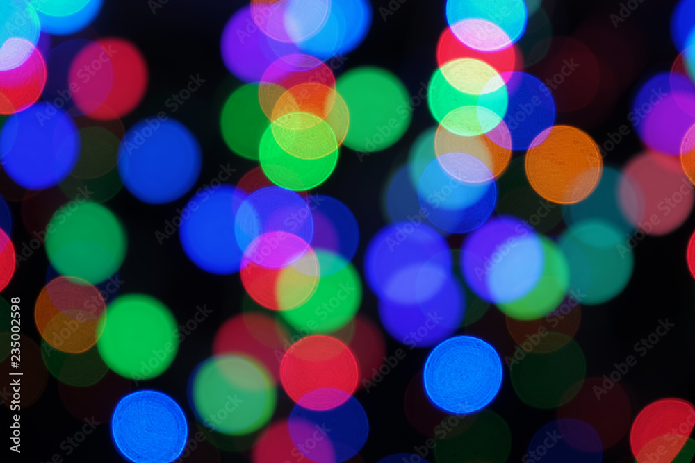 Blurred colorful big bokeh lights. Festive abstract background on black