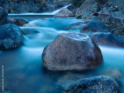 Rock in a steam surrounded with milky water motion - Cairngorm National Park, Scotland