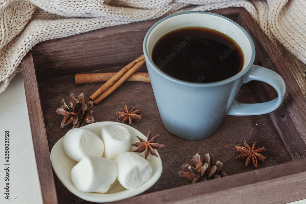Cup of coffee on rustic wooden tray, sweet marshmallow and warm woolen sweater. Cozy autumn or winter weekend or holidays at home. Fall home decoration with hot drink mug. Hygge morning style concept Cup of coffee on rustic wooden tray, sweet marshmallow and warm woolen sweater. Cozy autumn or winter weekend or holidays at home. Fall home decoration with hot drink mug. Hygge morning style concept