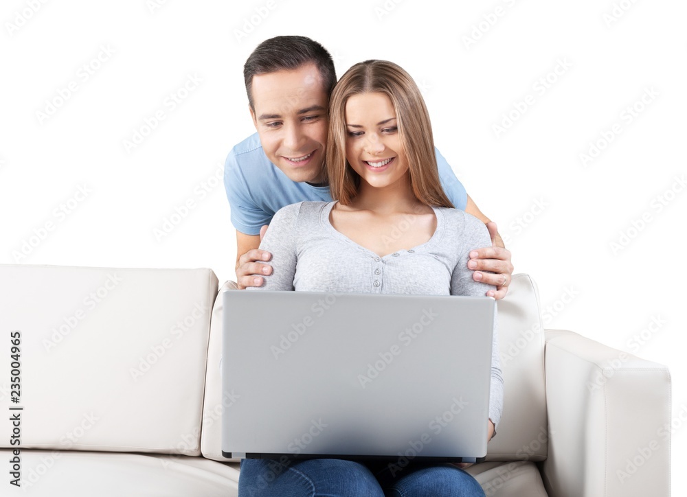 Smiling Couple Using Laptop on the Couch