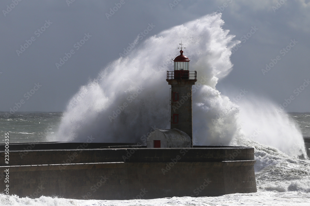 Big storm with big waves near a lighthouse