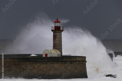 Big storm with big waves near a lighthouse