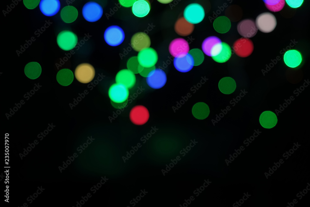 Blurred bokeh defocused festive lights. abstract background on black
