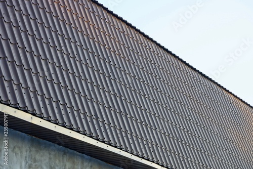 part of a building with a long roof under brown tiled tiles