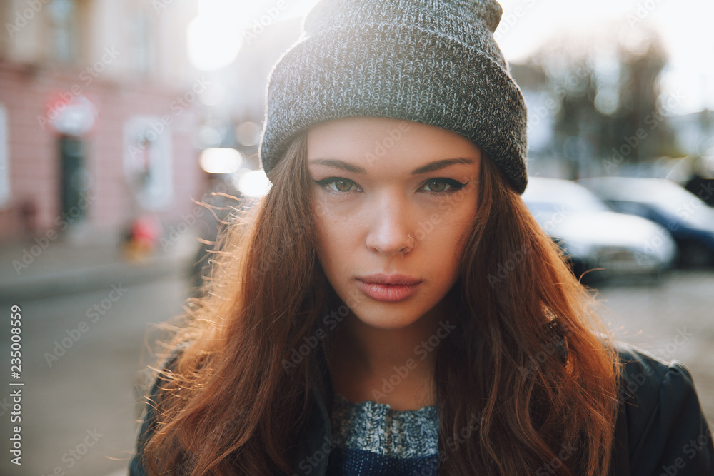 Large portrait of a girl in a hat on the street