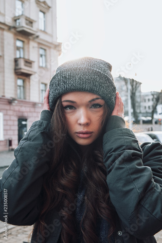 Large portrait of a girl in a hat on the street