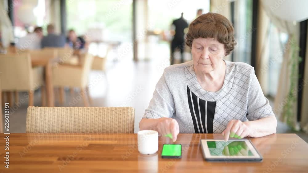 Senior Woman Using Phone And Digital Tablet While Drinking Coffee Senior Woman Using Phone And Digital Tablet While Drinking Coffee