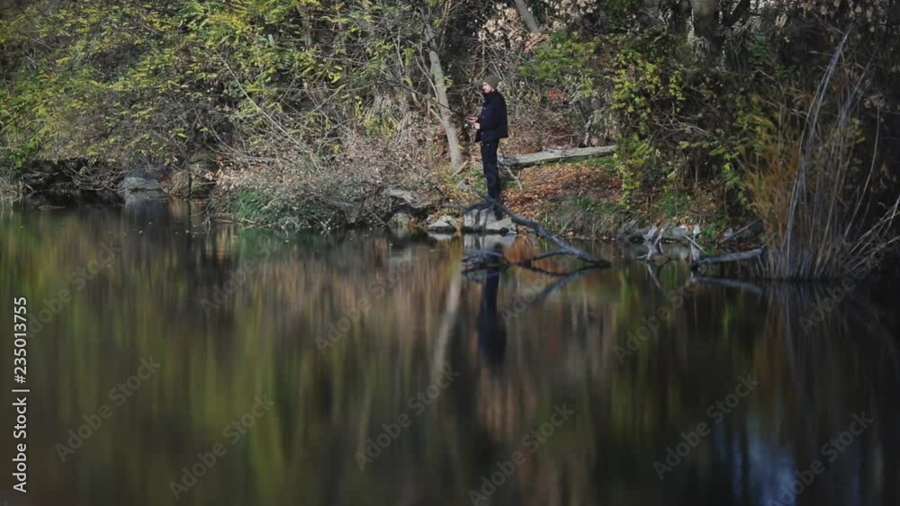 Fishing. Sport fishing. Catching predatory fish on spinning. Fishing on a wobbler. Fisherman fishes on the lake in late autumn at sunset.