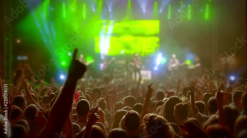 Large crowd of young people dancing at the rock 'n roll concert