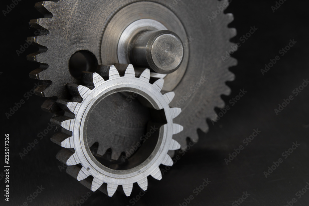 Gears on a metal workshop table. Spare parts for industrial machines. Gears on a metal workshop table. Spare parts for industrial machines.
