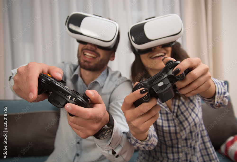 couple playing video games wearing virtual reality glasses. couple playing video games wearing virtual reality glasses.