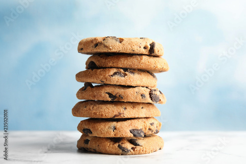 Stack of tasty chocolate chip cookies on table