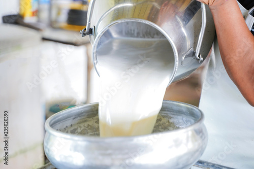 Worker pouring milk into  container tank for transform.