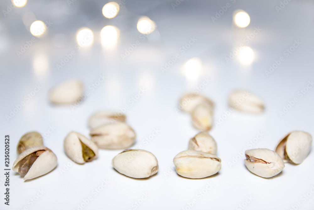 Pistachios on a white background with blurred lights in the background Pistachios on a white background with blurred lights in the background