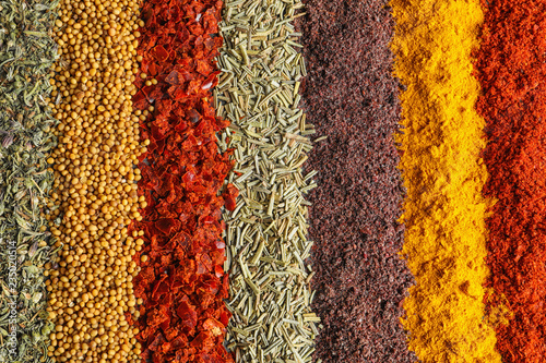 Rows of different aromatic spices as background, top view