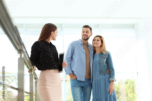 Female real estate agent showing new house to couple, indoors