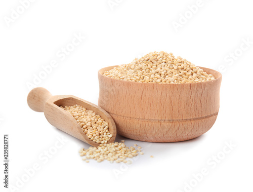 Bowl and scoop with raw quinoa on white background