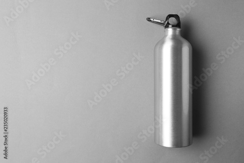 Sport bottle with space for text on color background, top view