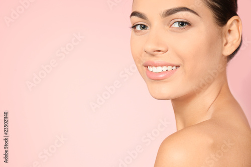 Portrait of beautiful young woman and space for text on color background. Cosmetic surgery concept