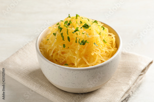 Bowl with cooked spaghetti squash on white table