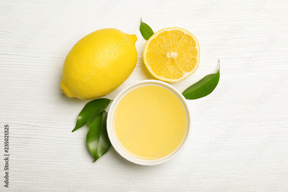 Composition with freshly squeezed juice and lemons on white wooden background Composition with freshly squeezed juice and lemons on white wooden background