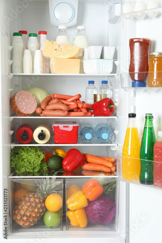Open refrigerator with many different products, closeup