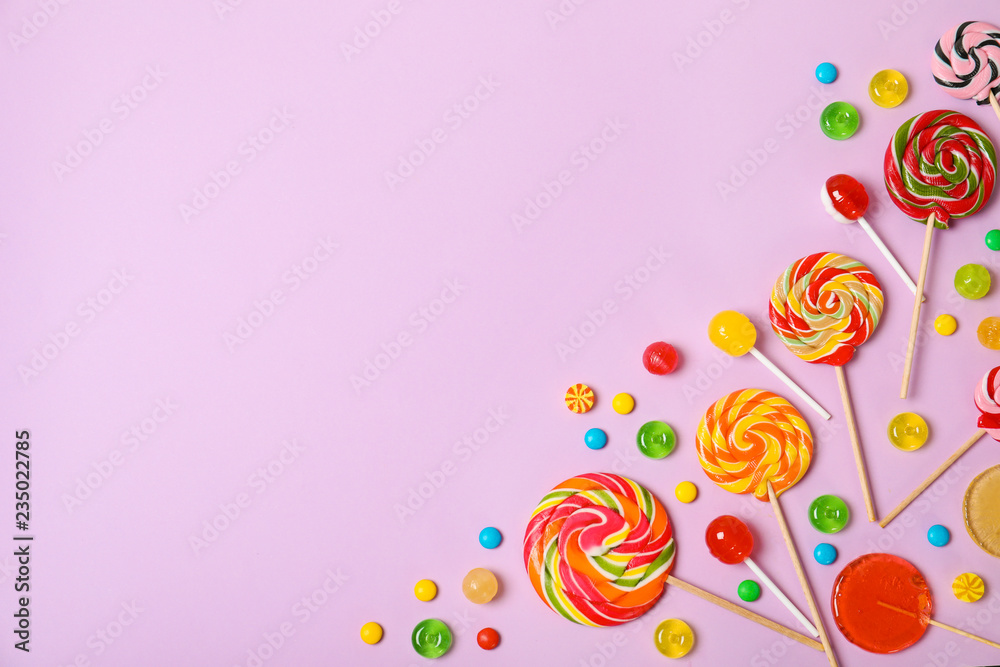Flat lay composition with different candies and space for text on color background