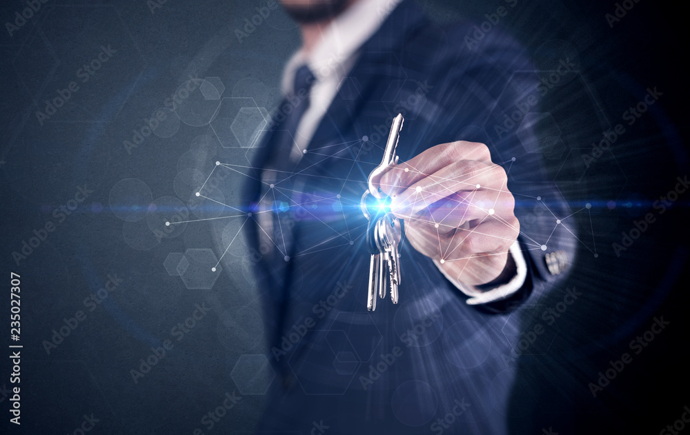 Fototapeta premium Businessman in suit holding over a key with connection concept around