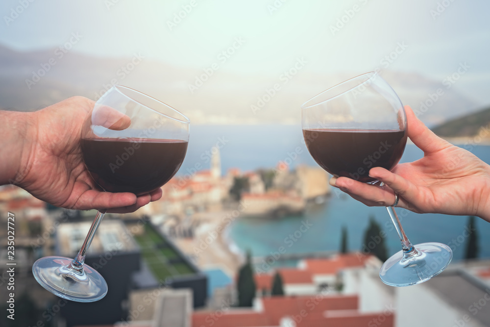 Man and woman holding glasses with red wine