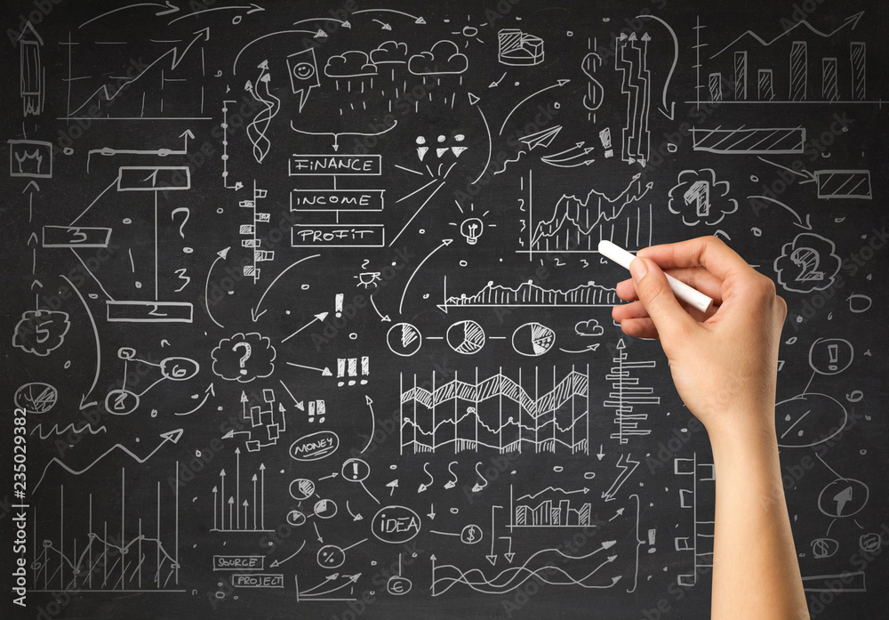 Female hand holding white chalk in front of a blackboard with a business plan drawn on it Female hand holding white chalk in front of a blackboard with a business plan drawn on it